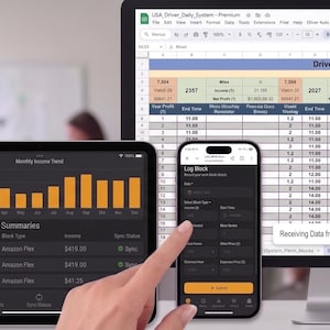 以下が含まれることがあります： Driver Daily Work Recordsというタイトルのスプレッドシートを表示するコンピュータモニター、月間収益トレンドの棒グラフを表示するタブレット、および入力フィールドを備えたログブロックインターフェースを表示するスマートフォンを含むデジタルワークスペース。