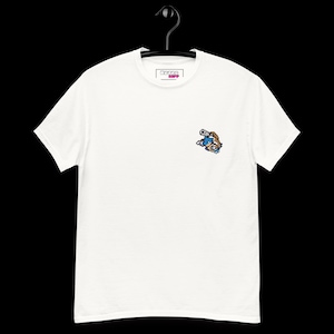 Puede incluir: Una camiseta blanca de manga corta con un pequeño gráfico de pixel art de una criatura azul y marrón en el pecho izquierdo. La etiqueta interior del cuello muestra el texto Retro Riff. La camiseta se presenta en una percha negra.