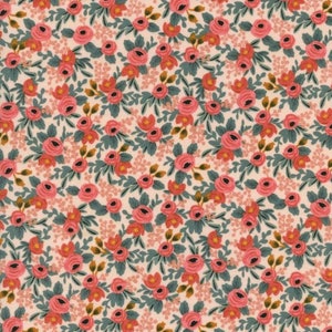 May include: A floral fabric featuring a repeating pattern of pink roses, small orange buds, and green leaves on a cream background. The design has a vintage aesthetic, suitable for quilting or crafting projects.