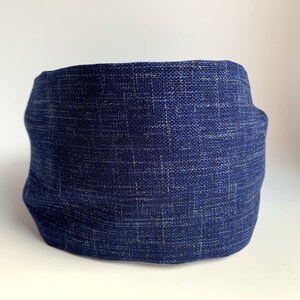 May include: A dark blue fabric headband with a textured woven pattern.