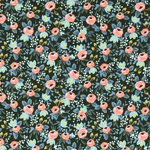 May include: A fabric with a floral pattern featuring peach-colored roses, light blue accents, and white sprigs on a dark green background. The design is a repeating pattern of flowers and leaves, creating a vintage or cottagecore aesthetic.
