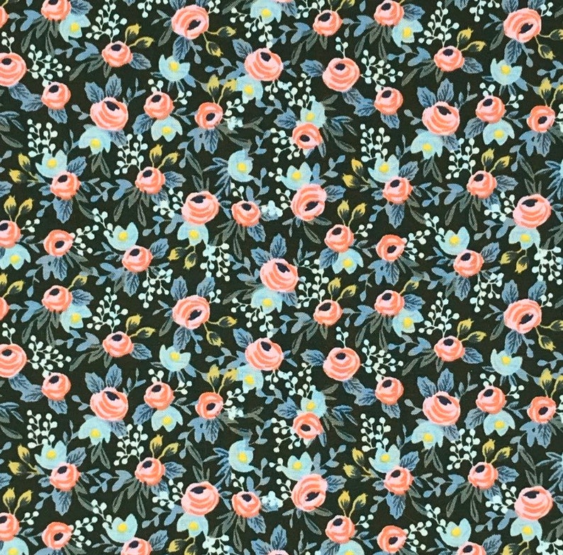 May include: A fabric with a floral pattern featuring peach-colored roses, light blue accents, and white sprigs on a dark green background. The design is a repeating pattern of flowers and leaves, creating a vintage or cottagecore aesthetic.