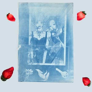 May include: A rectangular cyanotype print featuring a monochromatic blue illustration of two figures with detailed hairstyles and clothing. The print includes a clear rectangular overlay and is surrounded by four small, red, realistic strawberry illustrations.