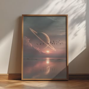 May include: A framed wall art print depicting a surreal landscape with a large ringed planet hovering above a calm ocean at sunset. A flock of birds flies across the sky, while soft clouds and the sun's reflection appear on the water's surface.