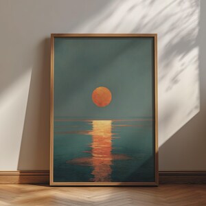 以下が含まれることがあります： 夕暮れ時のダークティール色の海景を描いた額装済みの縦型ウォールアートプリント。空の中央には大きく輝くオレンジ色の月が浮かび、その月が穏やかで暗い水面に明るくきらめくオレンジ色の反射を投げかけている様子が表現されています。