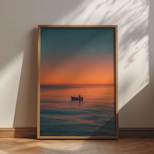 May include: A framed vertical wall art print depicting a small boat with a single figure on a calm ocean during a vibrant sunset. The horizon line separates a deep orange sky from the dark blue and orange reflective water in a serene composition.