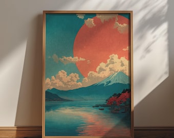 May include: A framed wall art print featuring a landscape illustration of a snow-capped mountain rising above a calm lake. A large, vibrant orange sun dominates the sky, partially obscured by white clouds, with reflections on the water surface.