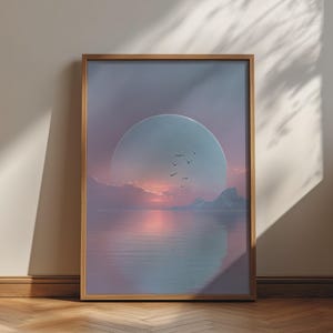 May include: A framed wall art print featuring a large, pale blue moon rising over a calm, reflective body of water. The scene includes a soft pink sunset, distant rocky silhouettes, and a small flock of birds flying across the centre of the moon.
