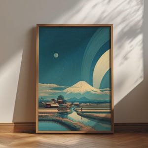 Op de afbeelding: Een ingelijste kunstdruk met een landschap met een besneeuwde berg, een klein dorp en een kronkelende rivier onder een donkerblauwe nachtelijke hemel met een grote planeet met ringen en een kleine maan, alles in een gestileerde artistieke stijl.