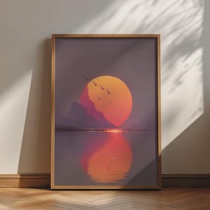 May include: A framed vertical wall art print featuring a sunset over a calm body of water. The scene displays a large orange sun partially obscured by dark purple mountains, with a flock of birds flying across the sky and a reflection on the water.