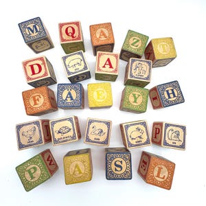 May include: A collection of twenty-four wooden alphabet blocks featuring various letters, animal illustrations, and Swedish text labels such as Gris, Elefant, Höna, Sköldpadda, Svan, Kanin, and Apa. Each cube displays colorful borders and patterns.
