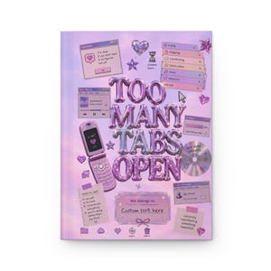 May include: A light purple notebook cover featuring the text "TOO MANY TABS OPEN" in metallic balloon-style letters. The design includes a flip phone, computer interface windows, a CD, and various icons like hearts and stars in a Y2K aesthetic.