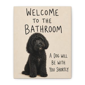 Könnte beinhalten: Ein rechteckiges Wandschild mit hellbeigem Hintergrund und einem schwarzen, lockigen Hund, der in der Mitte sitzt. Der Text lautet: WELCOME TO THE BATHROOM, A DOG WILL BE WITH YOU SHORTLY. Die Schrift ist in einem einfachen, dunklen Stil gehalten.