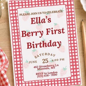 May include: A rectangular birthday invitation card featuring a red gingham border and a white background with a repeating pattern of small pink strawberries. The text reads: PLEASE JOIN US TO CELEBRATE Ella's Berry First Birthday SATURDAY JUNE 25 4:00 PM 462 Strawberry Ln Missoula, MT RSVP to London (123) 456-7890.