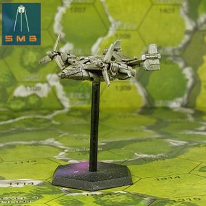 May include: A miniature silver-colored aircraft model with rotating propellers mounted on a black vertical stand and a hexagonal base. The vehicle features a cockpit, wings, and tail fins, presented as a tabletop gaming piece.