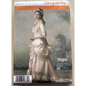 May include: A Simplicity sewing pattern envelope 4244 for a Victorian-style gown. The package features a photograph of a person wearing a champagne-colored dress with lace trim, a high collar, and a bustle. The text includes Simplicity, 4244, and Wrights.