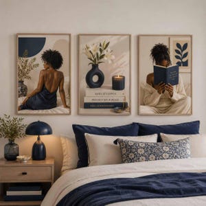 May include: A set of three framed wall art prints featuring a person in a dark blue dress, a navy vase with white lilies and a candle on stacked books labeled Make It Happen, Protect Your Peace, Feel Good Energy, and a person reading a blue book.
