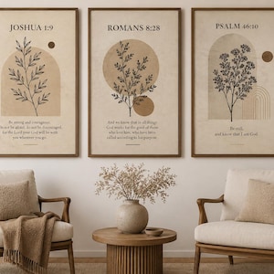 Może przedstawiać: Trzy oprawione grafiki ścienne z botanicznymi rysunkami liniowymi, geometrycznymi kształtami i wersetami biblijnymi. Wydruki przedstawiają Jozuego 1:9, Rzymian 8:28 i Psalm 46:10 czarnym tekstem na beżowym tle w ciemnobrązowych drewnianych ramach.