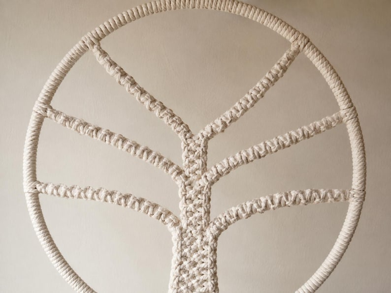 Pu&ograve; includere: Una decorazione da parete circolare realizzata in corda di cotone color bianco sporco con un design ad albero in macram&egrave;. La cornice esterna &egrave; un cerchio spesso di corda avvolta, con un tronco centrale e rami simmetrici annodati a mano.