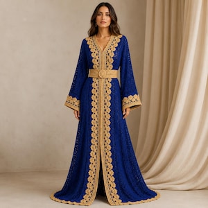 May include: A floor-length royal blue crochet dress featuring long, flared sleeves and a V-neckline. The garment is accented with intricate beige crochet trim along the neckline, front opening, and sleeve cuffs, and includes a matching belt.