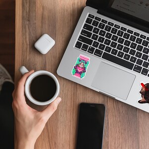 May include: A rectangular sticker featuring a stylized character with bright green hair, a pink outfit, and a dark collar, framed by red and white striped caution tape borders with the word CAUTION printed in white text at the top of the design.