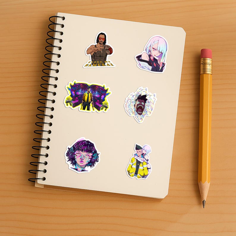 May include: A spiral-bound notebook featuring six anime-style stickers. The stickers depict various characters with vibrant colors, including a man with red sunglasses, a woman with light hair, a figure in a yellow jacket, and a person with purple hair.
