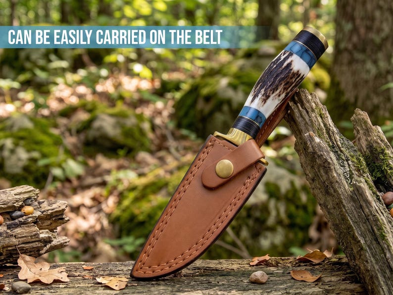 May include: A fixed-blade knife with a textured antler handle, blue accents, and a brass bolster, encased in a tan leather sheath with a brass snap closure. The text CAN BE EASILY CARRIED ON THE BELT is visible at the top of the image.