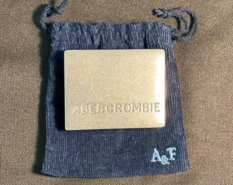 Vintage metalen riemgesp van Abercrombie & Fitch met zilveren plaatje en corduroy etui.