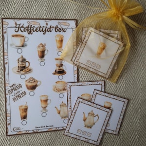 Op de afbeelding: Een spaarchallenge-kaart getiteld Koffietijd box met diverse koffie-illustraties, de tekst more ESPRESSO less DEPRESSO en een doel van 50 euro. Inbegrepen zijn diverse vierkante kaarten met koffieafbeeldingen in een geel organza zakje.