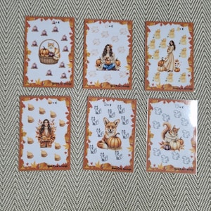 Op de afbeelding: Zes rechthoekige kaarten met herfstthema-illustraties en randen van oranje en bruine esdoornbladeren. Elke kaart toont kleine herhalende iconen en een centrale afbeelding, waaronder een kat in een mandje en een vos.