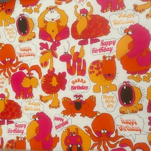 Puede incluir: Una tela blanca con un patrón repetido de criaturas de dibujos animados de color naranja, rosa y amarillo. Las criaturas tienen diferentes formas y tamaños, y algunas tienen manchas o rayas. La tela tiene las palabras "Happy Birthday" impresas.