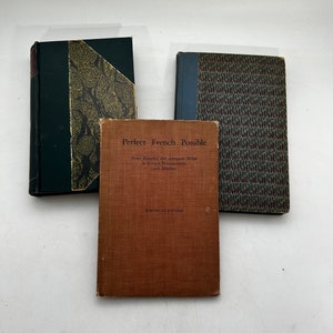May include: Three hardcover books with patterned covers. The book in the center has the title "Perfect French Possible" with the subtitle "Some Essential and Adequate Helps to French Pronunciation and Rhythm" and the author "Knowles Fayard".