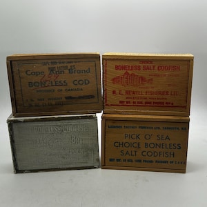 May include: Four rectangular wooden boxes for salt codfish. Top left: Cape Ann Brand Boneless Cod. Top right: R. E. Newell Fisheries Ltd. Choice Boneless Salt Codfish. Bottom left: Boneless Codfish. Bottom right: Pick O' Sea Choice Boneless Salt Codfish.