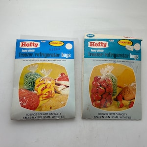 Puede incluir: Dos bolsas Hefty vintage para congelador/refrigerador. El embalaje azul y blanco presenta imágenes de alimentos. Un paquete está etiquetado como "80 bolsas capacidad 1 cuarto, 10cm x 5cm x 30cm, 95mil con lazos". El otro está etiquetado como "80 bolsas capacidad 1 pinta, 10cm x 5cm x 20cm, 95mil con lazos."