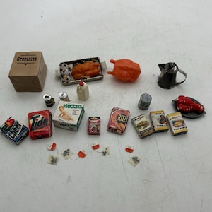 May include: Miniature food items including a brown paper grocery bag, a roasted chicken, a metal pitcher, and various packaged goods like Tide detergent and Ritz crackers. A whimsical collection of tiny groceries.
