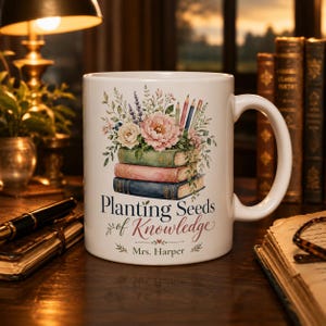 May include: A white ceramic mug featuring a colorful illustration of three stacked books topped with flowers and pencils. The text reads "Planting Seeds of Knowledge" above the name "Mrs. Harper" in a decorative script and serif font.