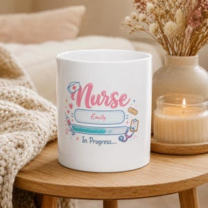 Può includere: Una tazza in ceramica bianca con una grafica colorata e il testo Nurse Emily In Progress. Il design include illustrazioni di una cuffia da infermiere, una siringa, un cerotto, una cartella clinica e uno stetoscopio in rosa, blu e giallo.