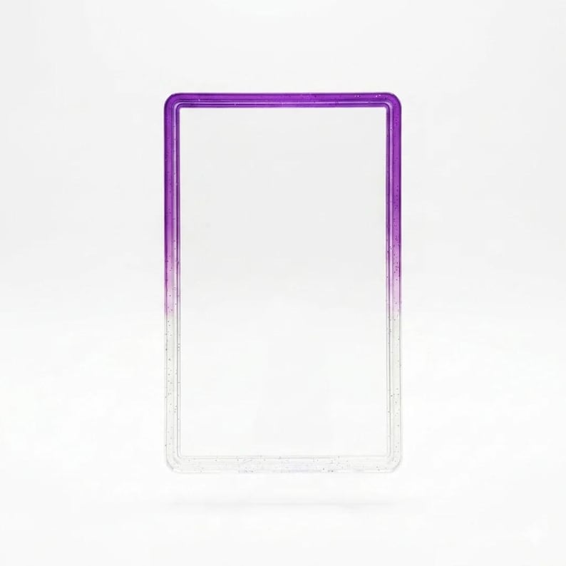 May include: A rectangular card holder frame featuring a clear center and a purple gradient border. The frame has a smooth, glossy finish with a subtle glitter effect embedded within the material, transitioning from deep purple at the top to clear.