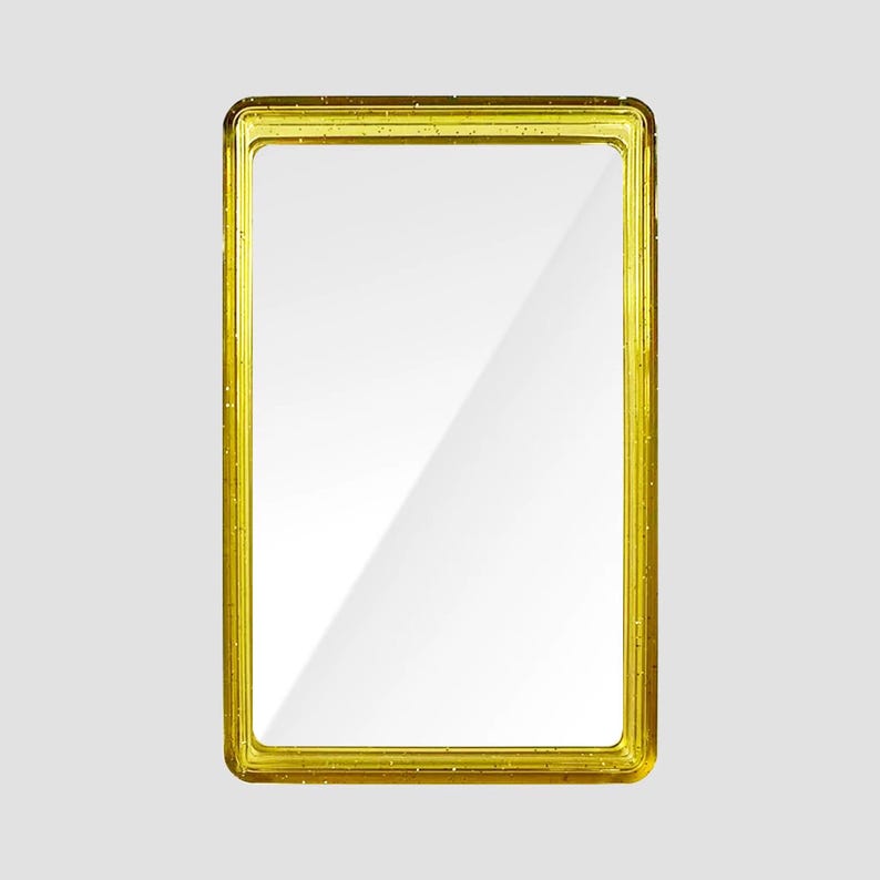 May include: A rectangular mirror featuring a translucent yellow frame with embedded glitter particles. The mirror has a smooth, reflective glass surface with a clean, simple border design that surrounds the central rectangular reflection area.