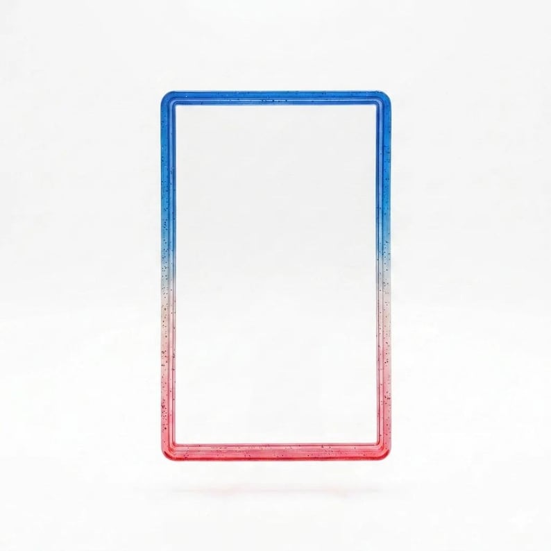 May include: A rectangular frame with a smooth, glossy finish featuring a color gradient that transitions from blue at the top to red at the bottom. The frame has a clear, hollow center and is embedded with fine, subtle glitter throughout the material.