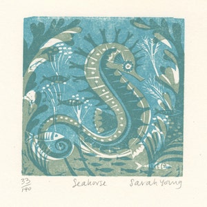 May include: A blue and green linocut print of a seahorse surrounded by seaweed and fish. The print is numbered 33/140 and signed "Seahorse" and "Sarah Young".
