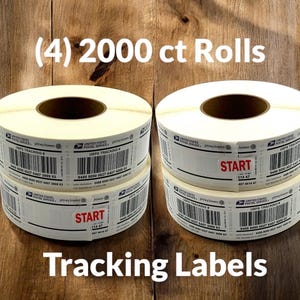 Op de afbeelding: Vier rollen witte zelfklevende verzendlabels, elk met 2000 stuks. De labels zijn voorzien van zwarte USPS-trackingbarcodes, United States Postal Service-branding en Pitney Bowes-logo's. Twee rollen hebben een rode START-sticker op de zijkant.