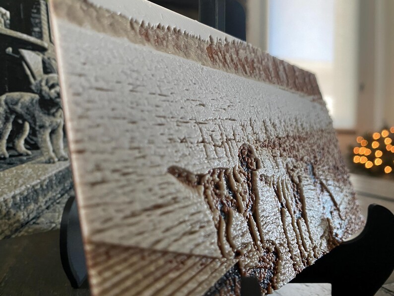 K&ouml;nnte beinhalten: Eine rechteckige Platte mit einem strukturierten Reliefbild eines Hundes, der auf einem Feld steht. Die Oberfl&auml;che hat eine cremefarbene und hellbraune Farbpalette mit einer rauen, taktilen Textur und steht auf einem schwarzen St&auml;nder.