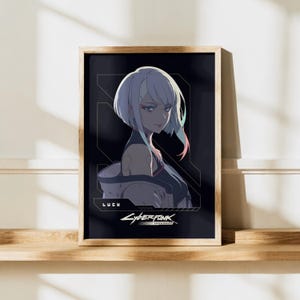 May include: A framed rectangular wall art print featuring an anime-style character with short white hair and pink highlights. The character is named Lucy, with the text Cyberpunk Edgerunners printed below in a dark, stylized graphic design.