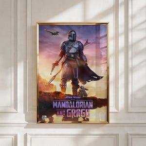 Op de afbeelding: Een ingelijste verticale poster met de Mandalorian in zilveren harnas en Grogu staand op een rotsachtige klif tegen een zonsonderganghemel. Een ruimteschip vliegt in de verte. De tekst luidt Star Wars The Mandalorian and Grogu in paars.
