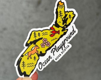 May include: A yellow sticker in the shape of Nova Scotia with a black outline. The sticker features a horse, lobster, trees, flowers, and the text "Ocean Playground Nova Scotia". The sun is at the top.