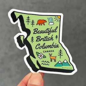 May include: A green sticker in the shape of British Columbia, Canada, with black outlines. The sticker features illustrations of a bear, waterfall, trees, mountains, and a deer. Text reads "Beautiful British Columbia CANADA".