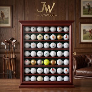 May include: A rectangular wooden display case with a glass front containing forty-two golf balls arranged in seven rows of six. The case features a dark mahogany finish and a small gold latch. The logo JW JaTiWood is printed above the cabinet.