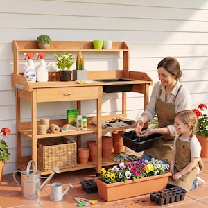 May include: A wooden potting bench with a top shelf, a drawer, and a lower storage area. The bench features a built-in black sink basin, two spray bottles, a wicker basket, twine, and various gardening supplies on the shelves.
