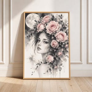 Puede incluir: Una impresión de arte mural enmarcada que presenta una ilustración en acuarela de una persona con cabello oscuro adornado con rosas de color rosa suave. Una luna llena grande y luminosa es visible en el fondo oscuro, contrastando con el retrato.